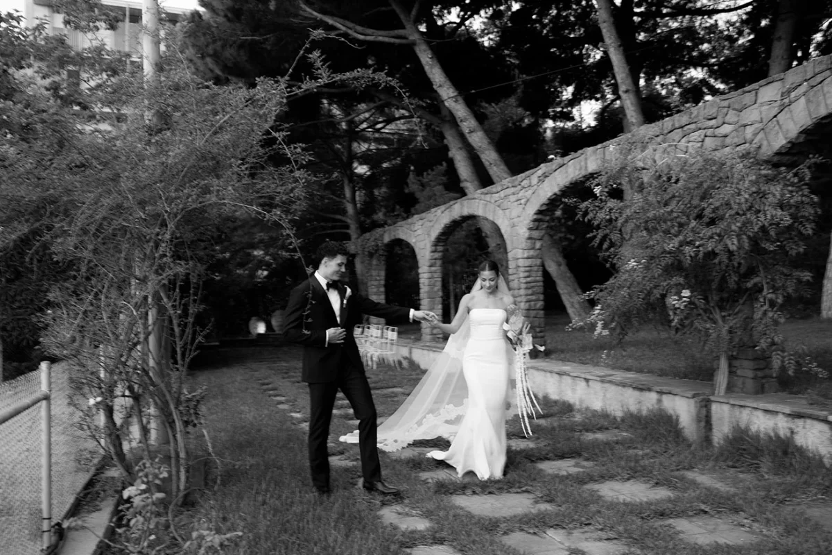 Fotografia de la parella de nuvis caminant, presa des de lluny durant el casament, realitzada per Aida López.